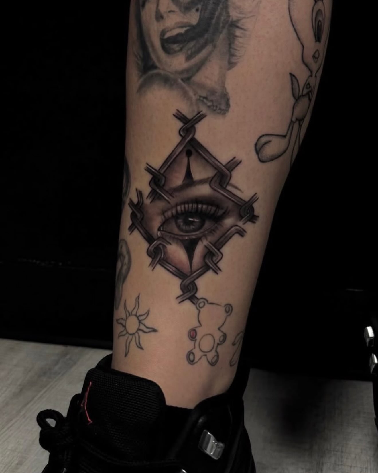 Eye with barbed wire geometric tattoo on the forearm by Amber Lynn