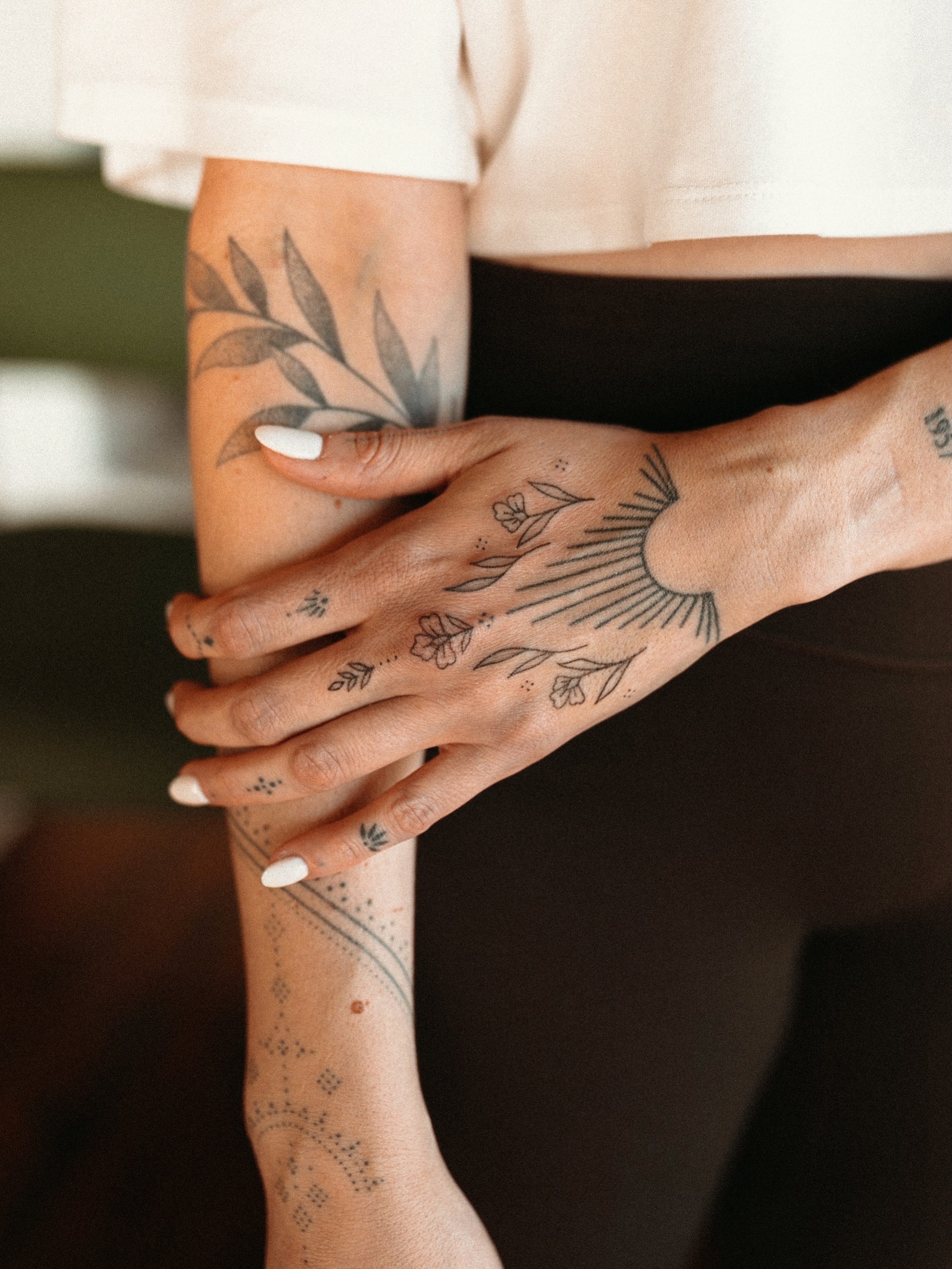 Sunburst and floral dotwork tattoo on the forearm by Grace Wise - Handpoke Tattoos
