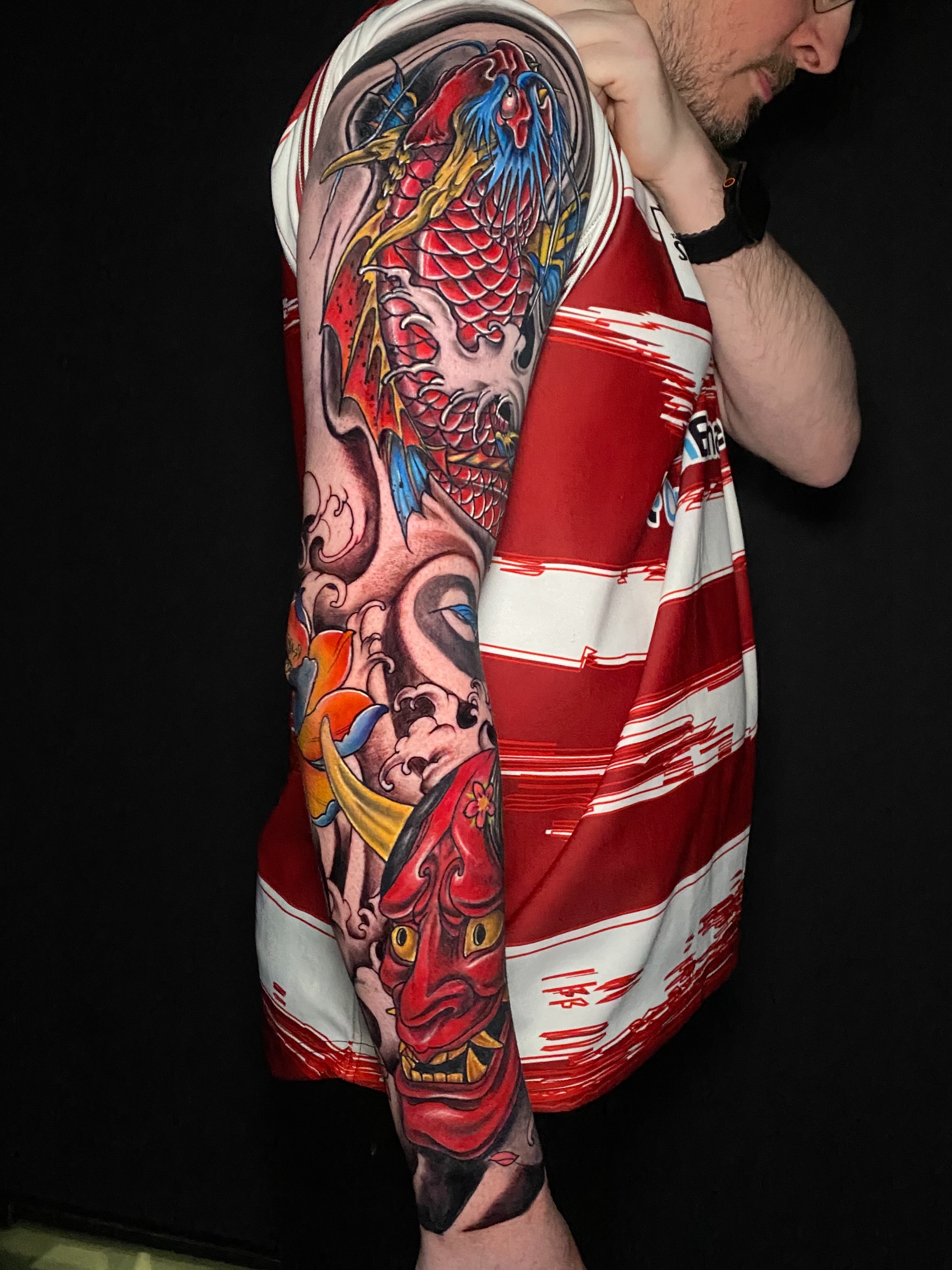 Koi fish and mask japanese irezumi tattoo on the upper arm by @dom_macio_tattoo