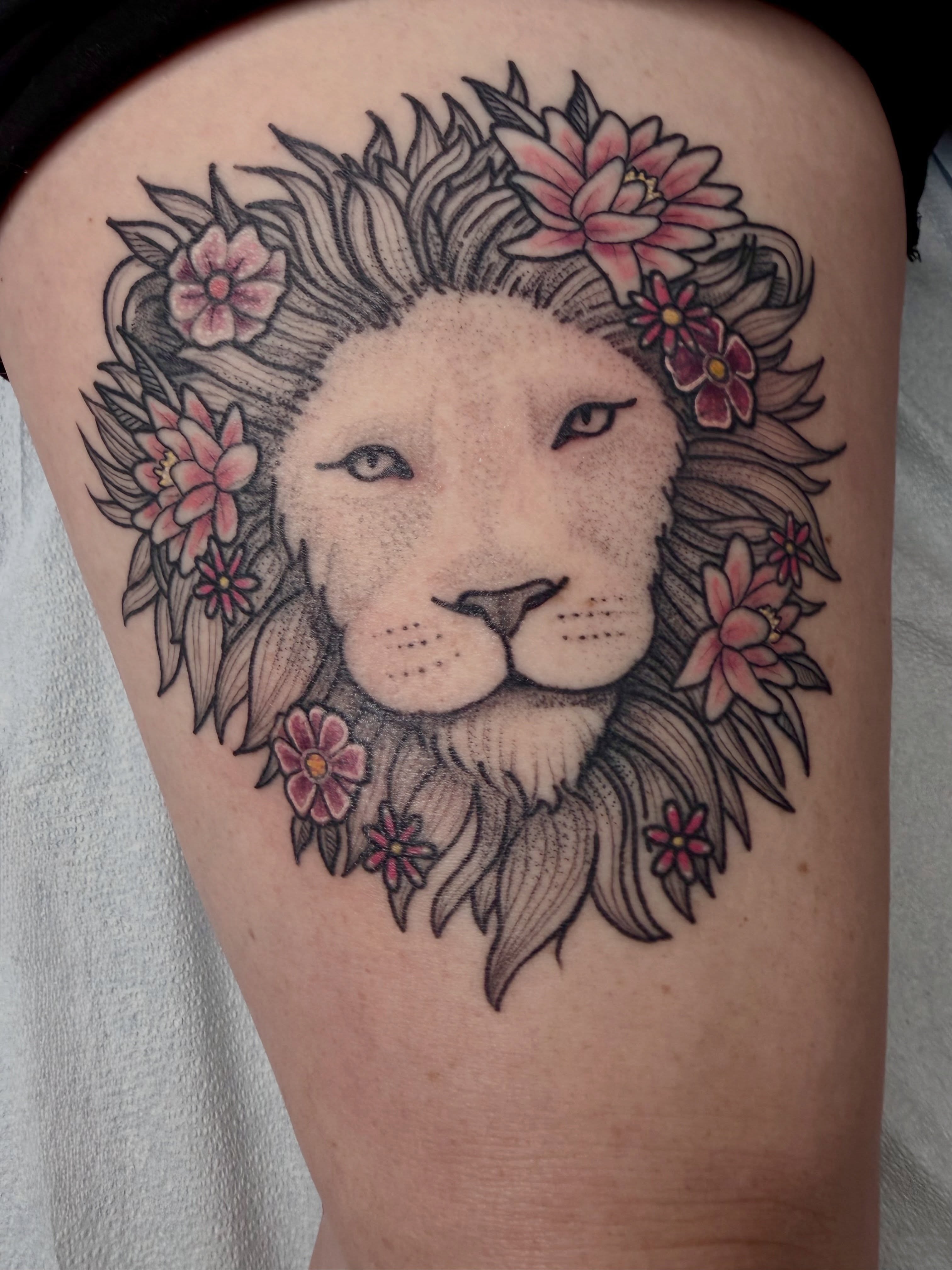 Lion with floral crown dotwork tattoo on the thigh by AJ Jensen
