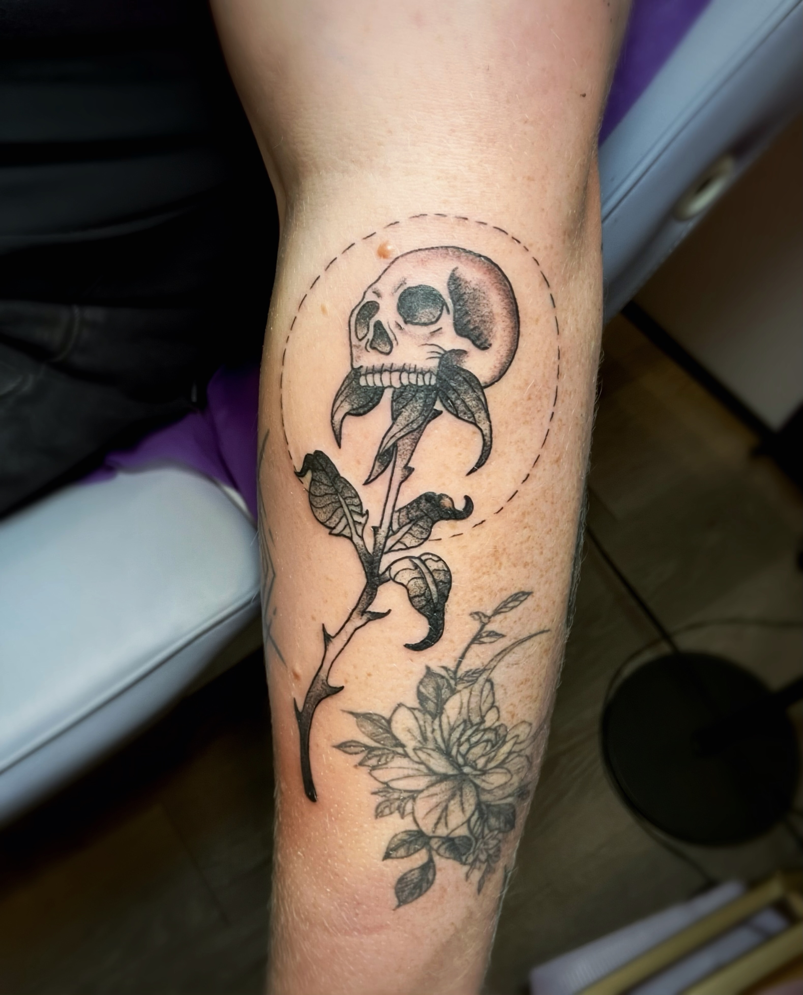 Skull and flower black and grey tattoo on the forearm by Shay Cole