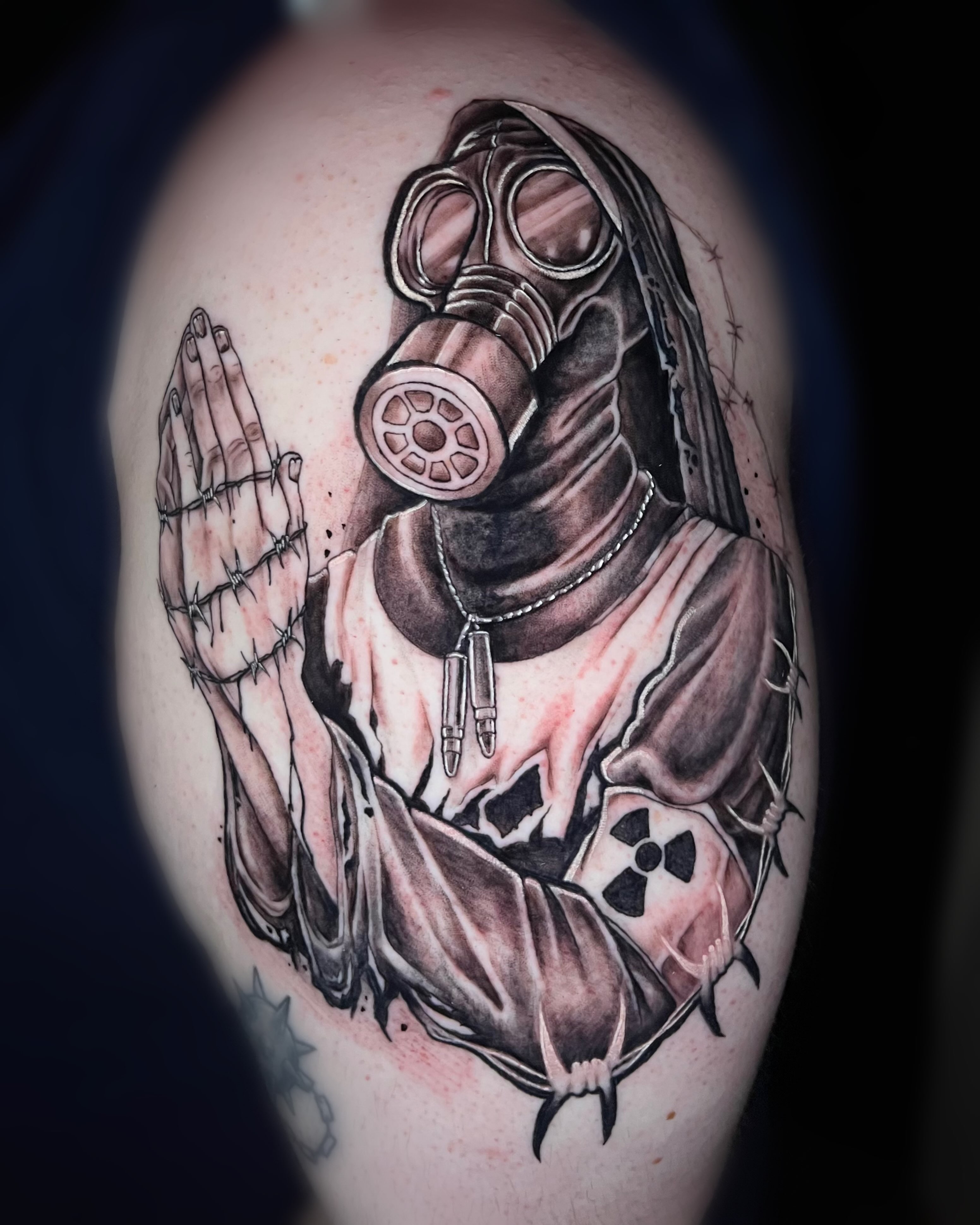 Gas mask and hands dark realism tattoo on the shoulder by Saint