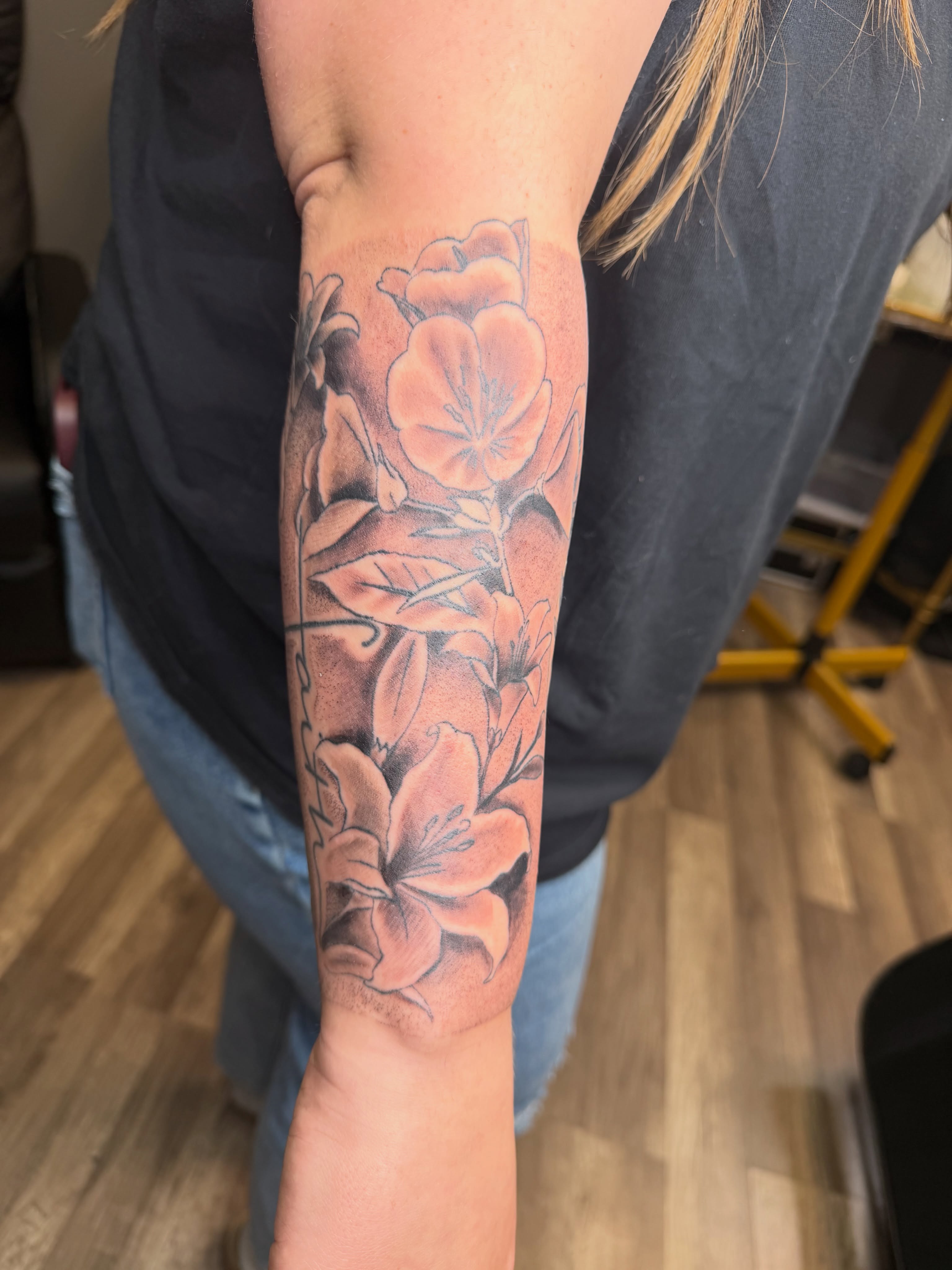 Flowers black and grey tattoo on the forearm by Rain David