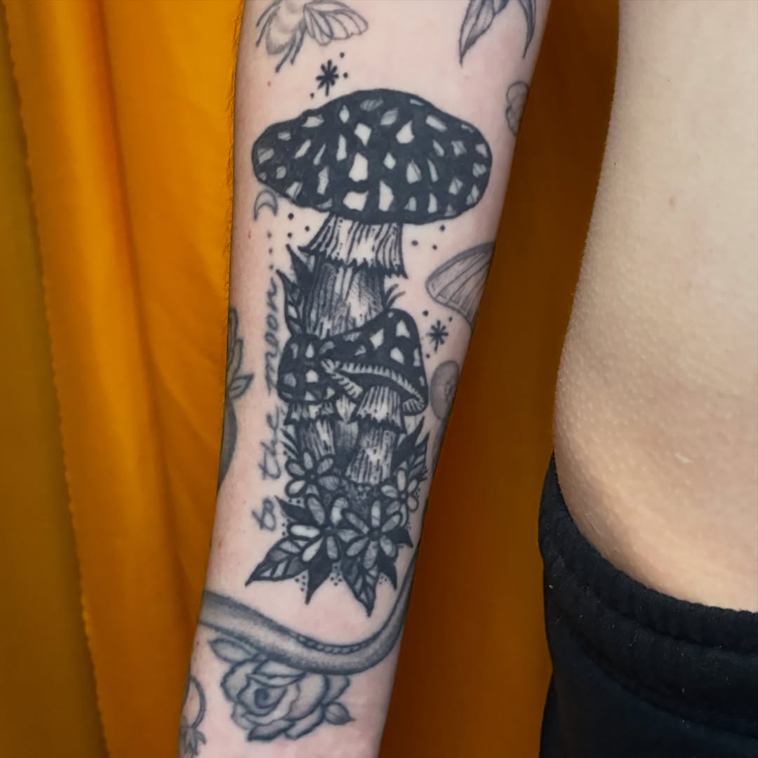 Mushroom and flowers black and grey tattoo on the forearm by Kaily McKee