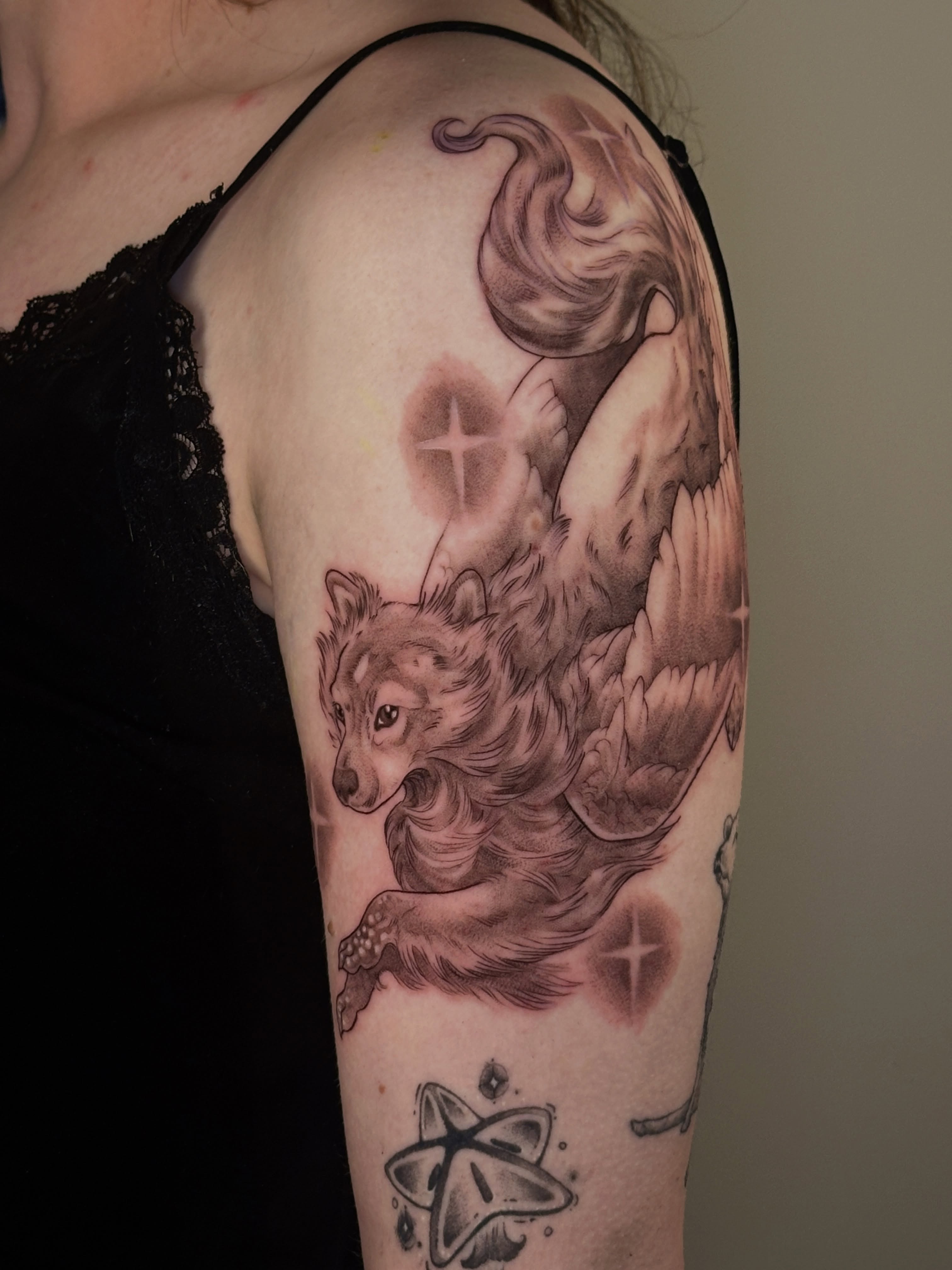 Wolf with wings realism tattoo on the upper arm by katie, Seattle, Washington