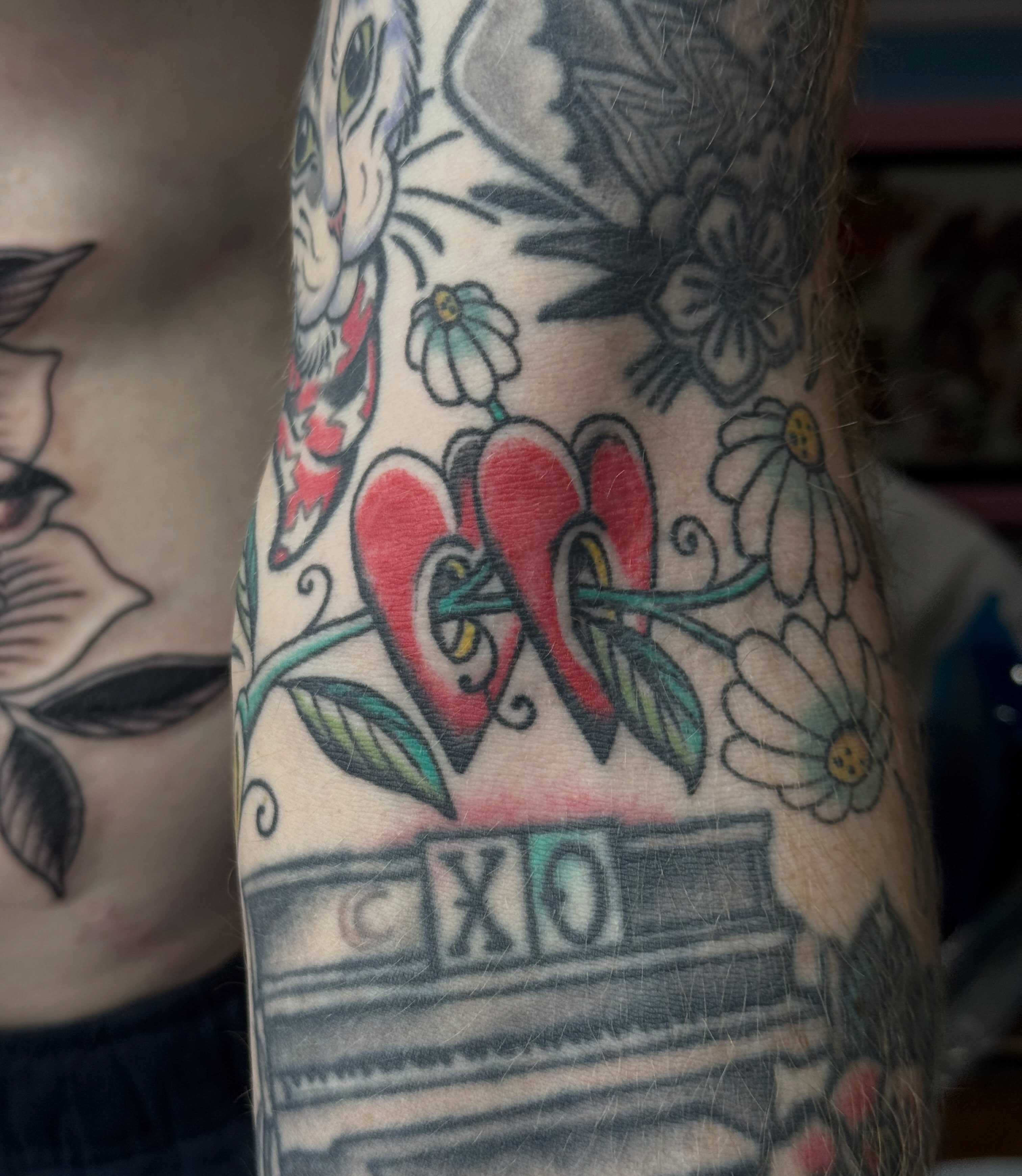 Hearts and flowers American traditional tattoo on the forearm by B