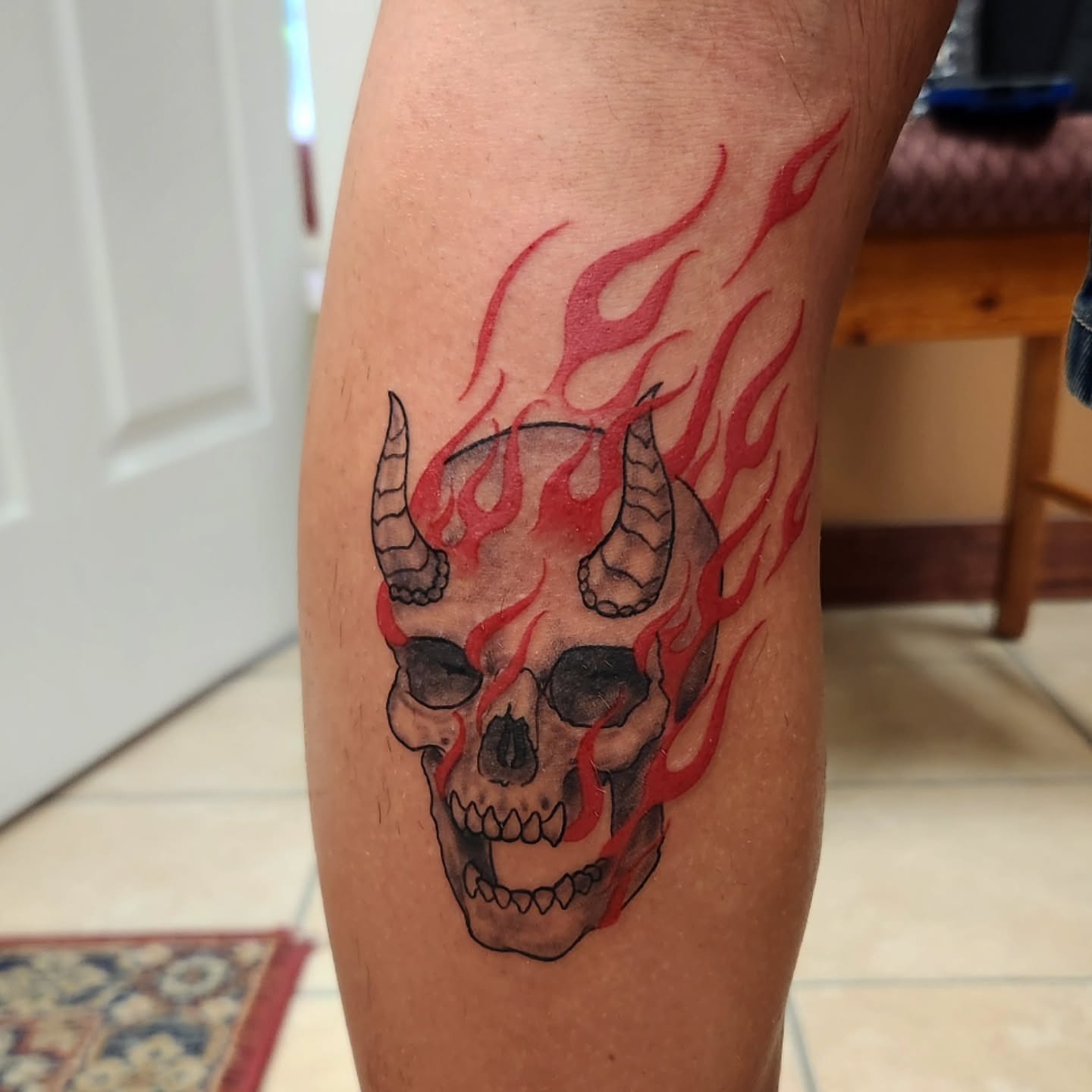 Flaming skull neo-traditional tattoo on the forearm by Arthur Whitney Shail