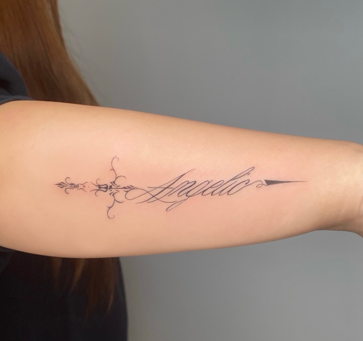 Angelic lettering script tattoo on the forearm by 𝓖𝓻𝓪𝓬𝓮 𝓑𝓮𝓵𝓵
