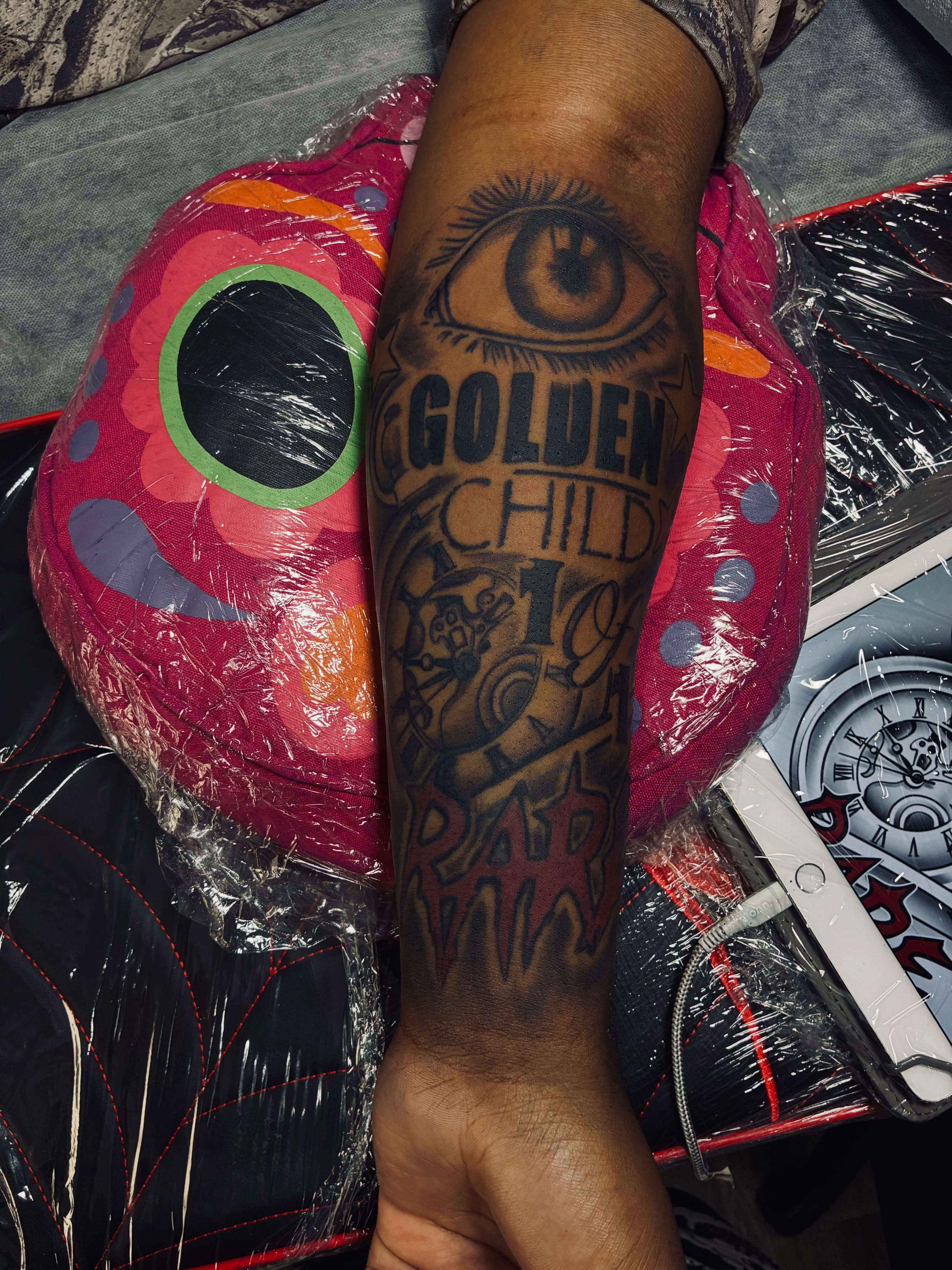 Golden child black and grey tattoo on the forearm by Nessa, Las Vegas, Nevada