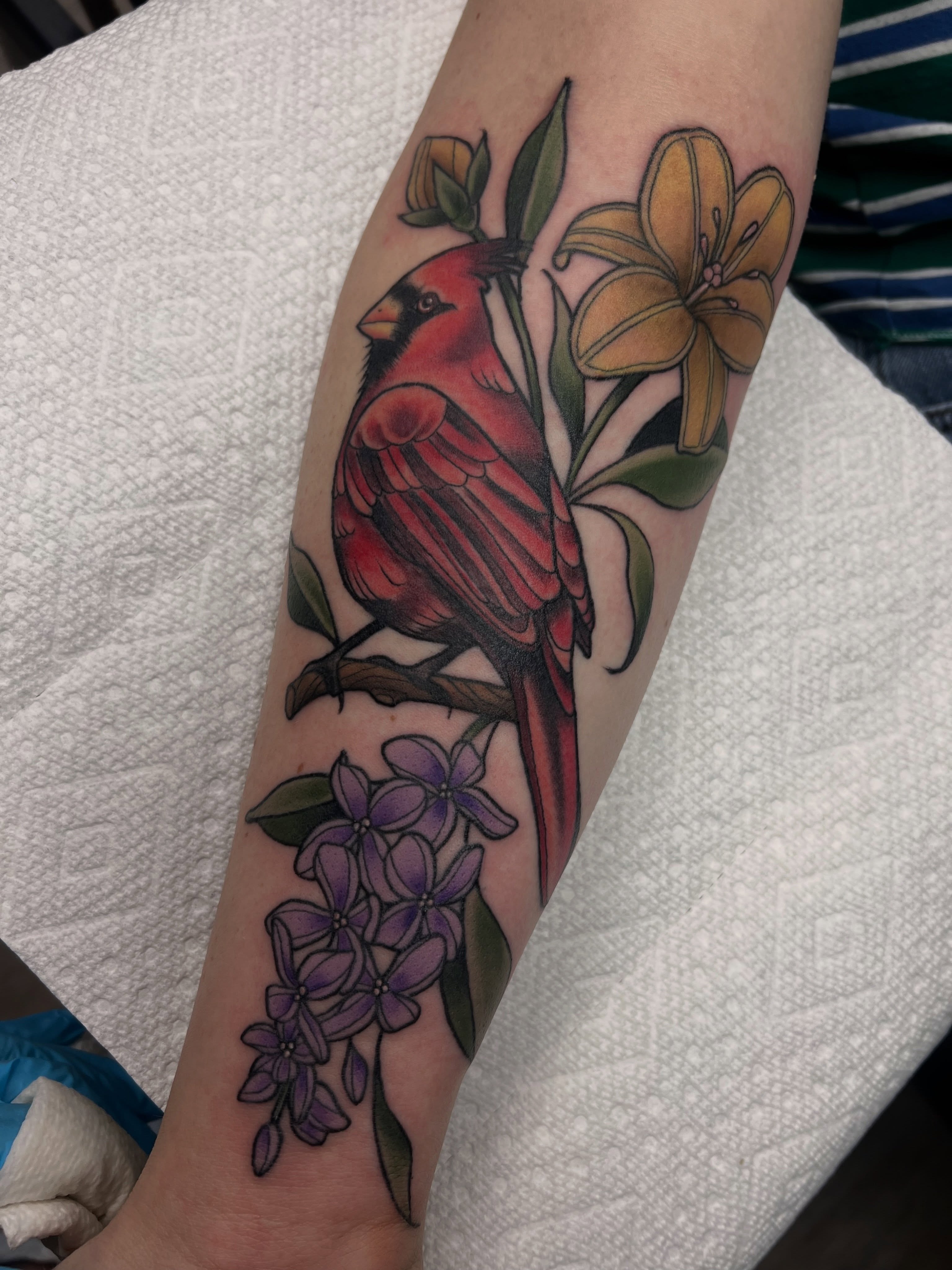 Cardinal and flowers realism tattoo on the forearm by Olivia Suzanne Fada