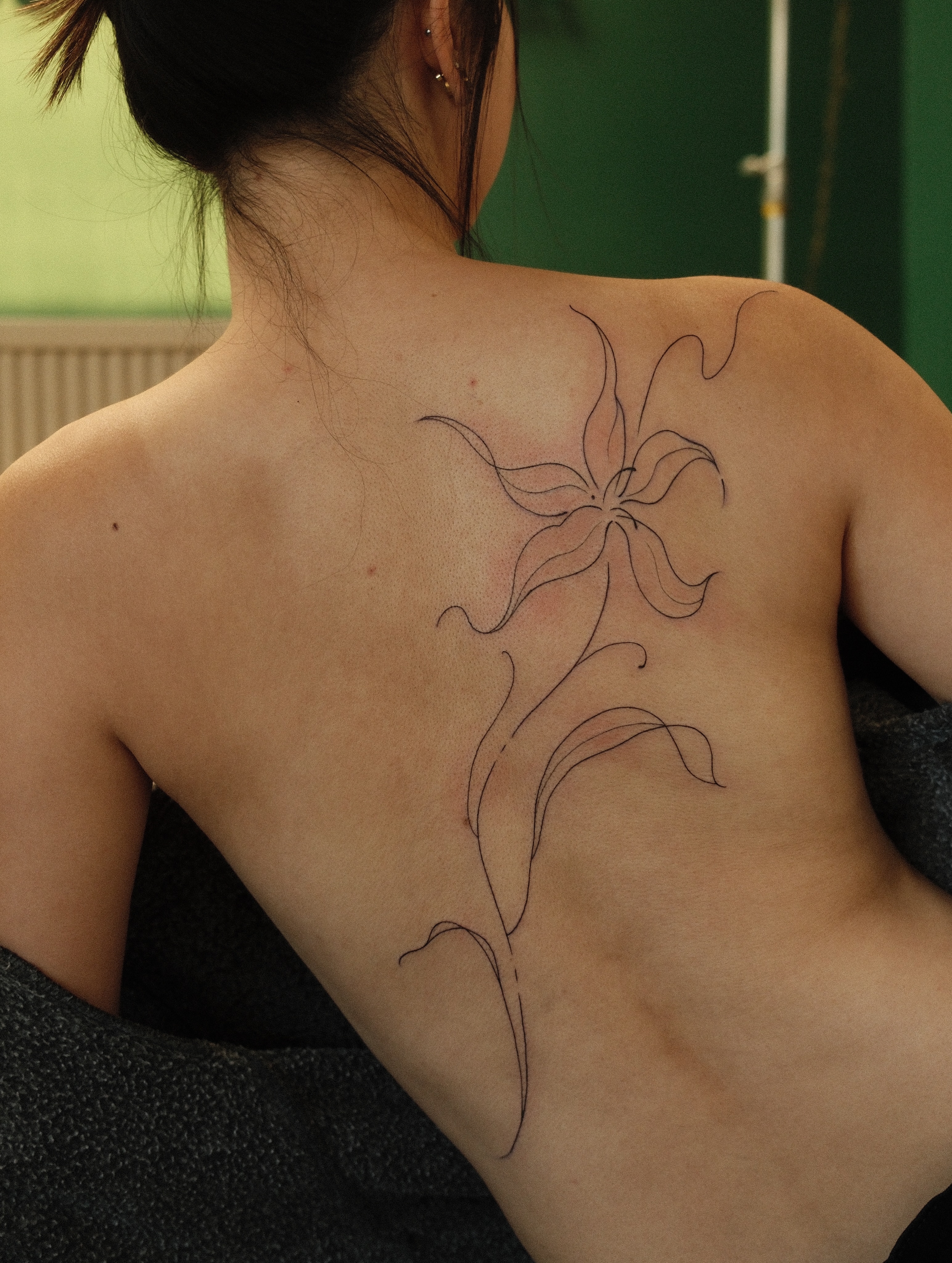 Flower fine line tattoo on the back by v?