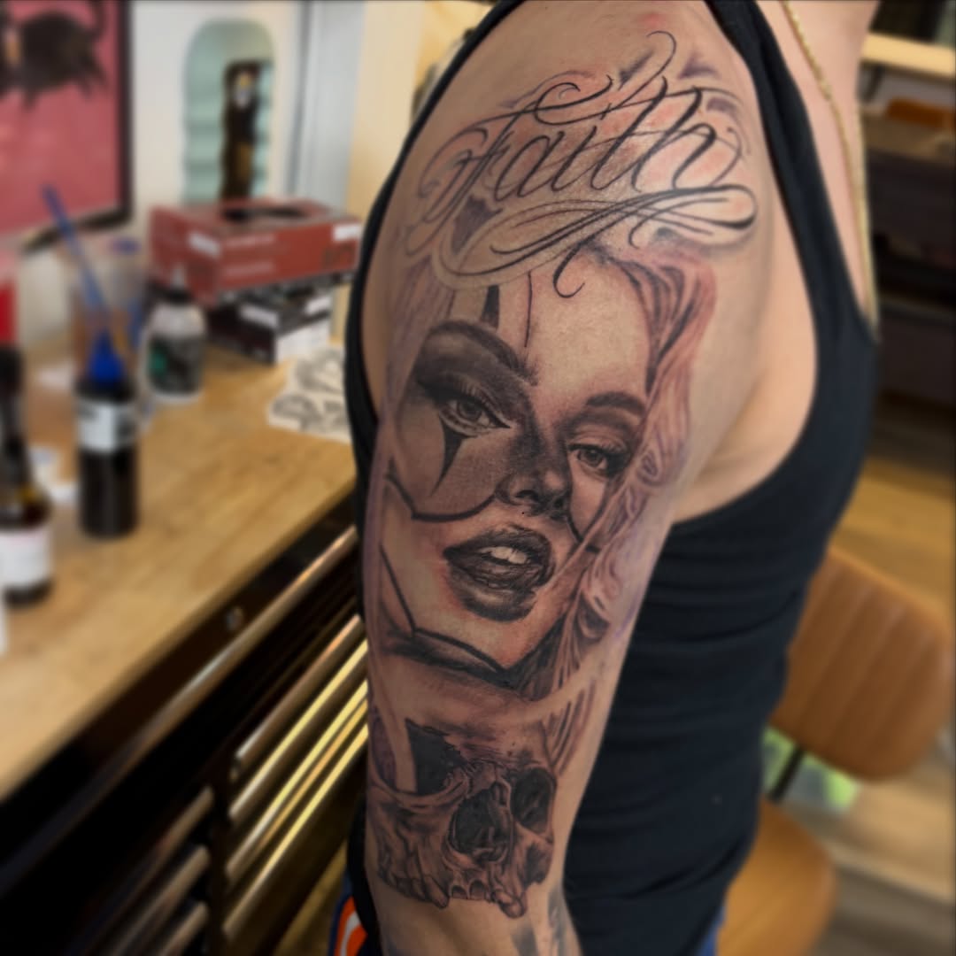 Woman's face realism tattoo on the upper arm by Haley