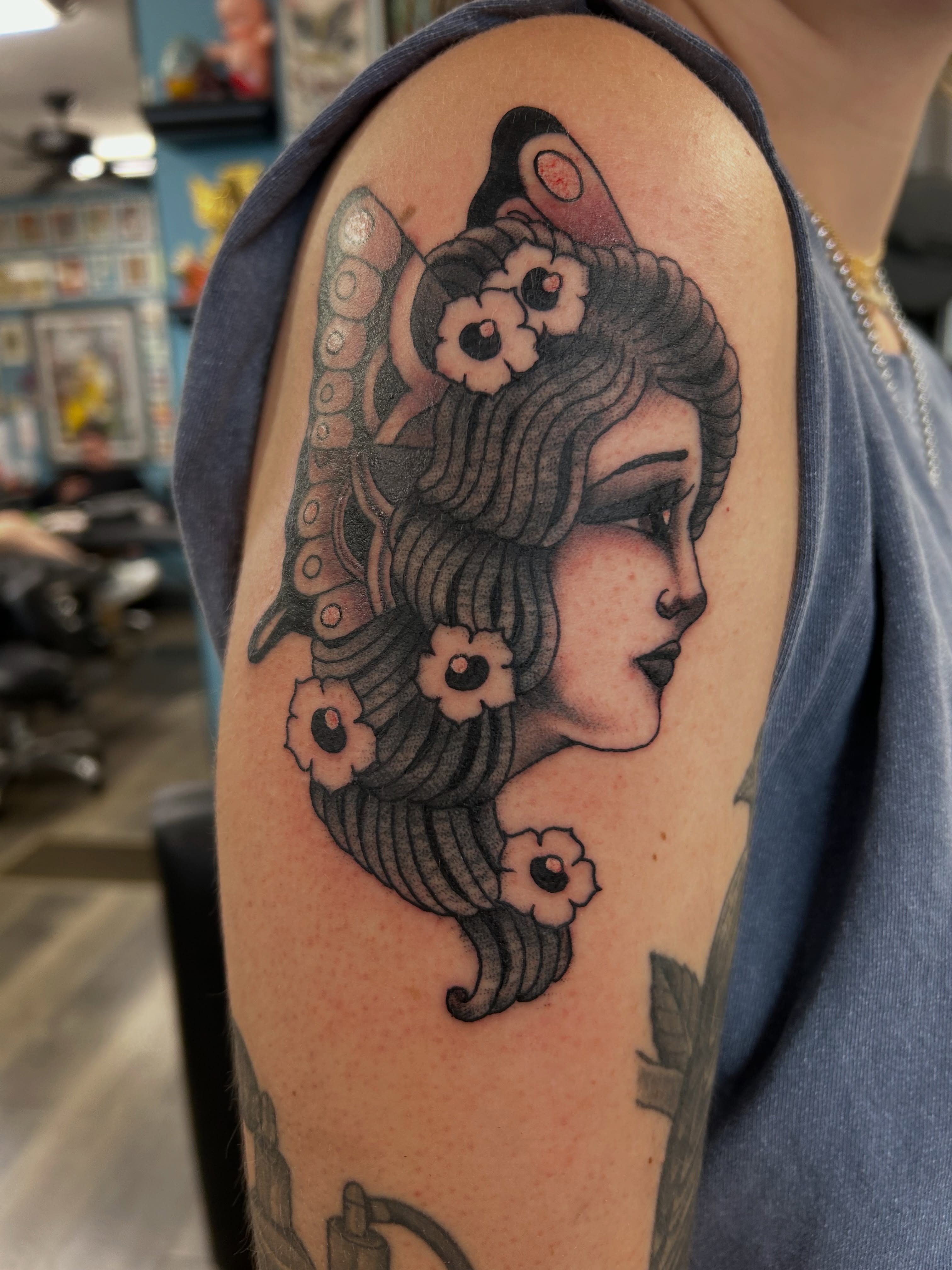 Woman with flowers American traditional tattoo on the shoulder by Mike "Yogi" Trube