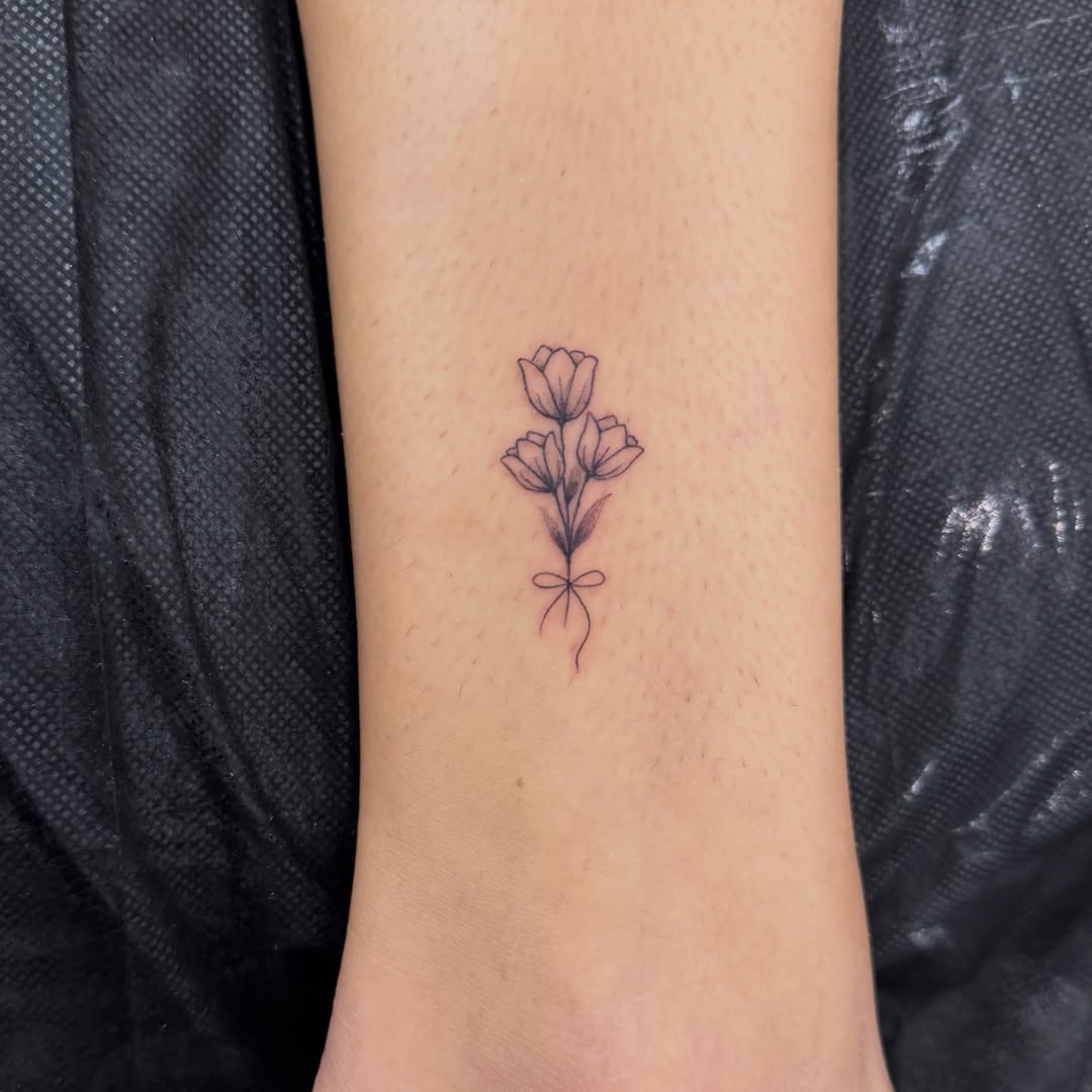 Flower bouquet black and grey tattoo on the forearm by Alex