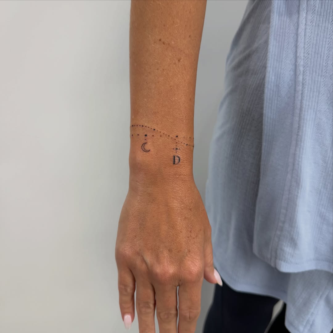 Dots and crescent moon dotwork tattoo on the forearm by Alex