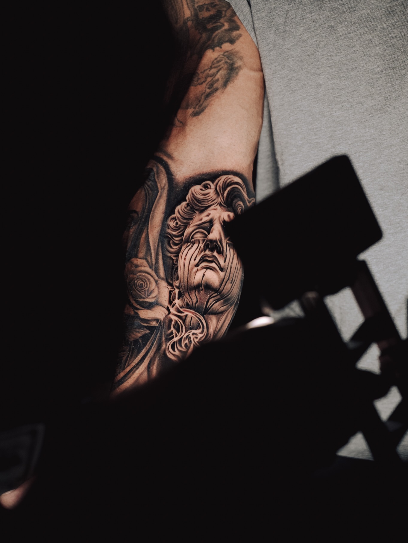 Statue head realism tattoo on the upper arm by Ray Paponetti - Tattoo Artist Delray Beach