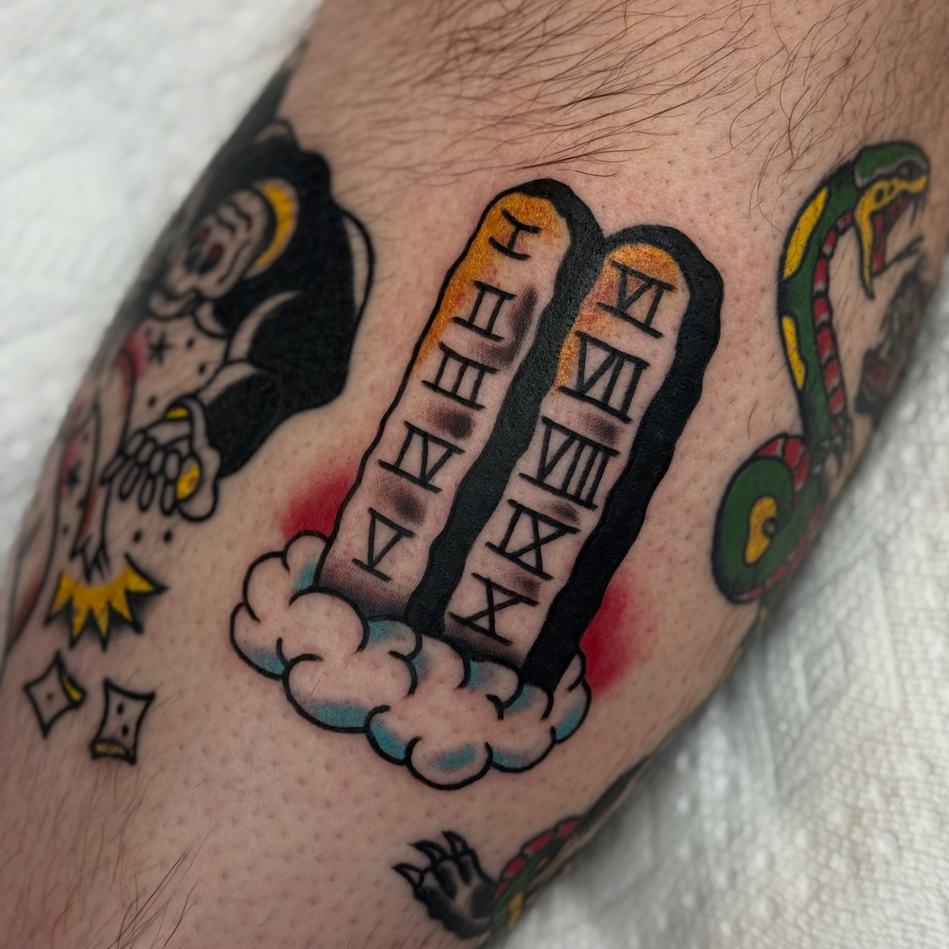 Jester and Roman numerals American traditional tattoo on the forearm by Ben