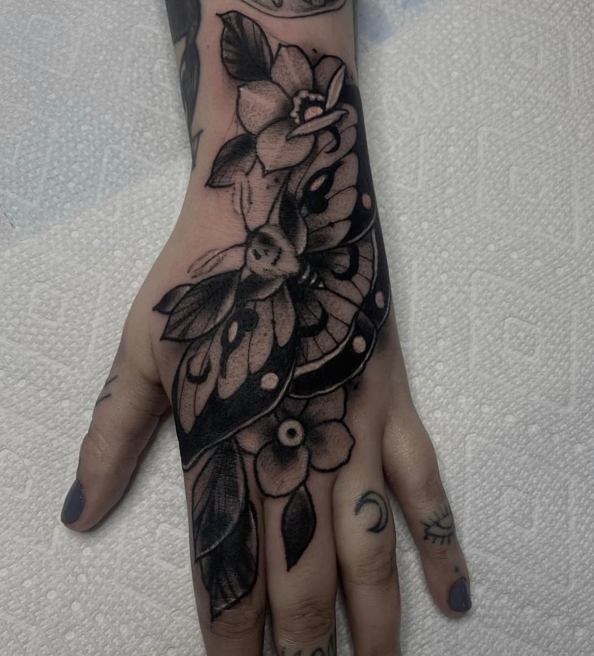Butterfly and flowers black and grey tattoo on the hand by ๐ฎ๐๐๐ฐ ๐๐ซ๐ค๐ข๐ฉ๐ฌ ๐๐๐ฆ๐๐ซ๐ฬ
