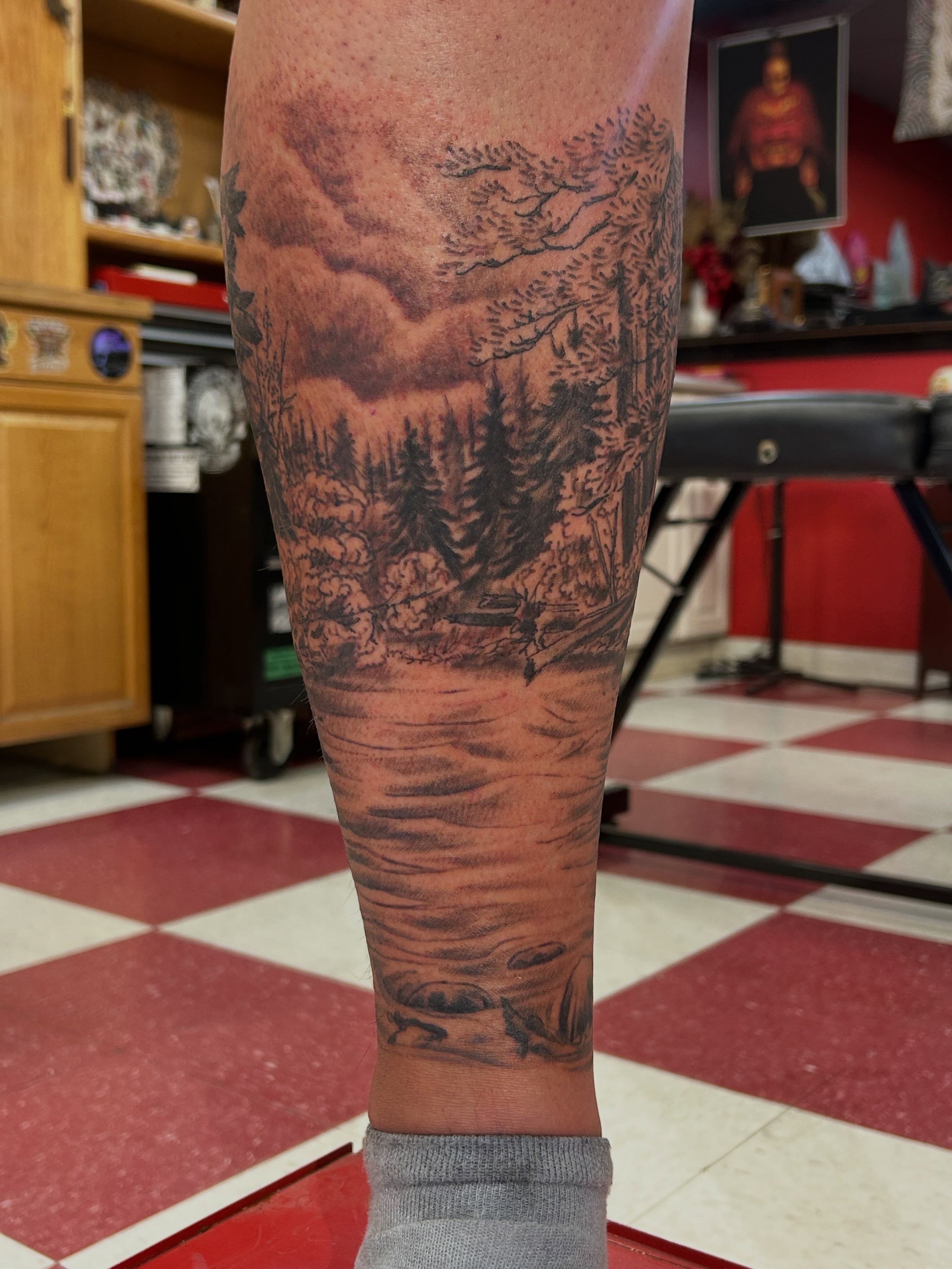 Lake landscape realism tattoo on the forearm by Jim Rosal