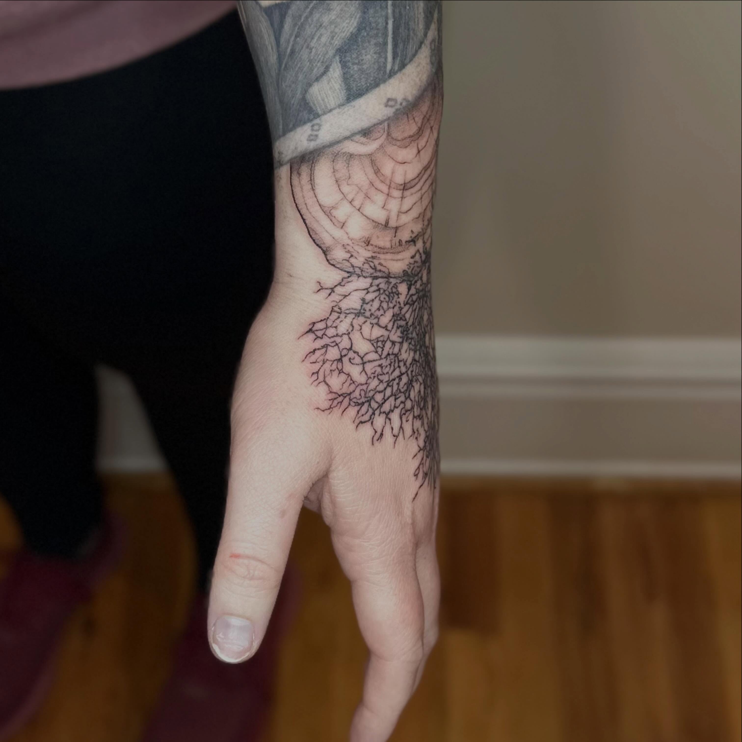 Root system fine line tattoo on the forearm by Micha Sol