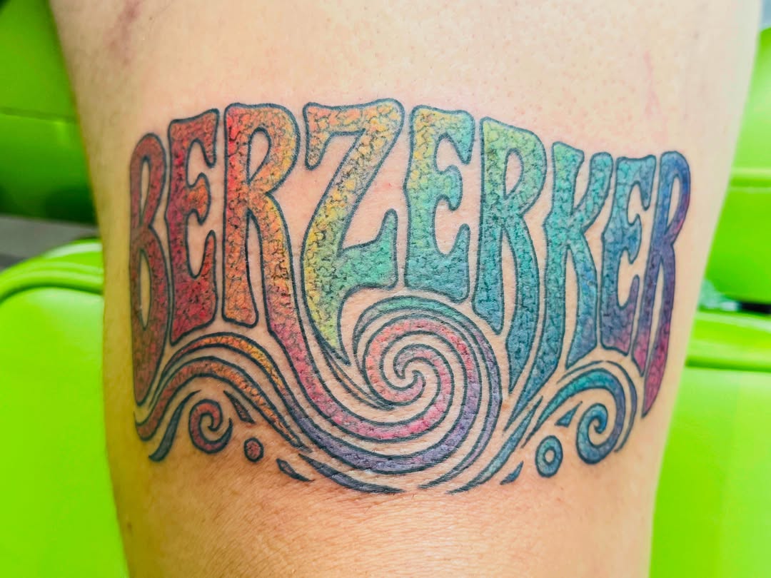 Berzerker lettering script tattoo on the thigh by Cristal Bidoul