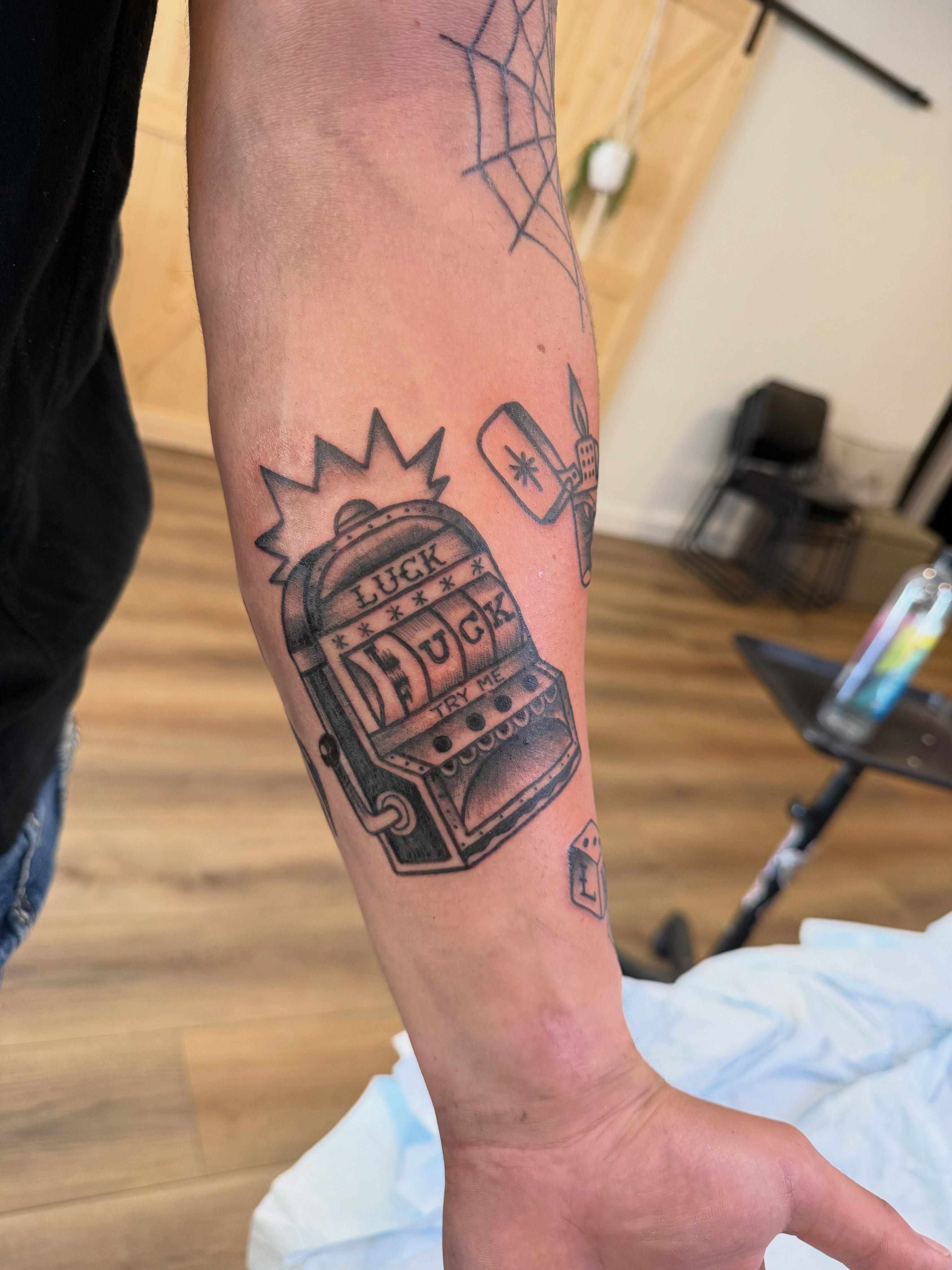 Slot machine black and grey tattoo on the forearm by Krystal Harris