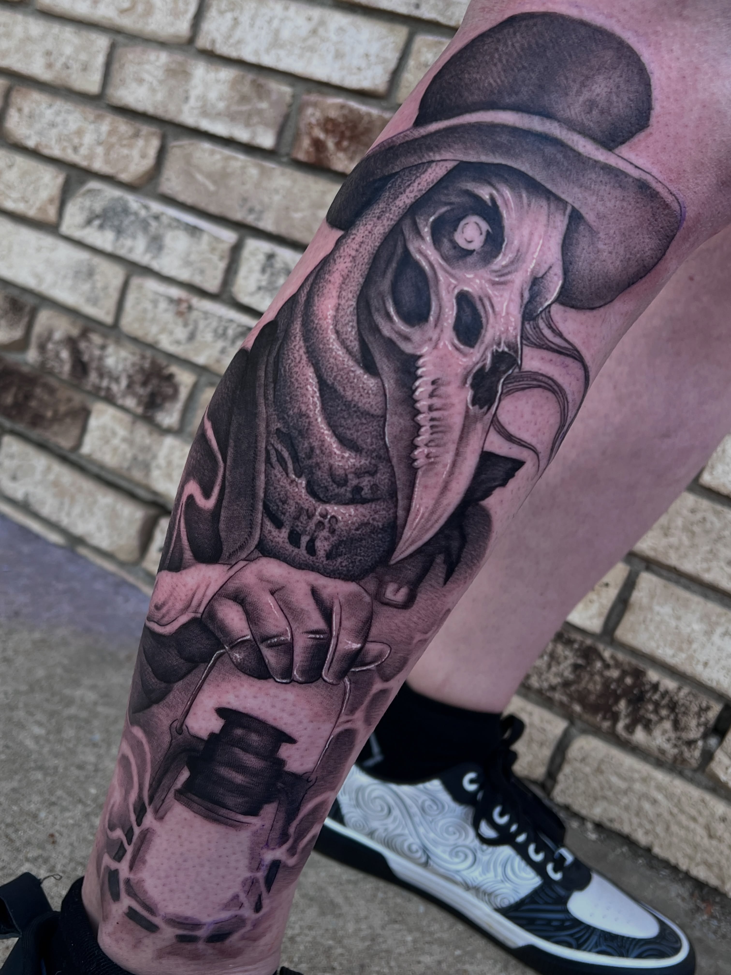 Skull wearing top hat realism tattoo on the forearm by @divineink_nyc