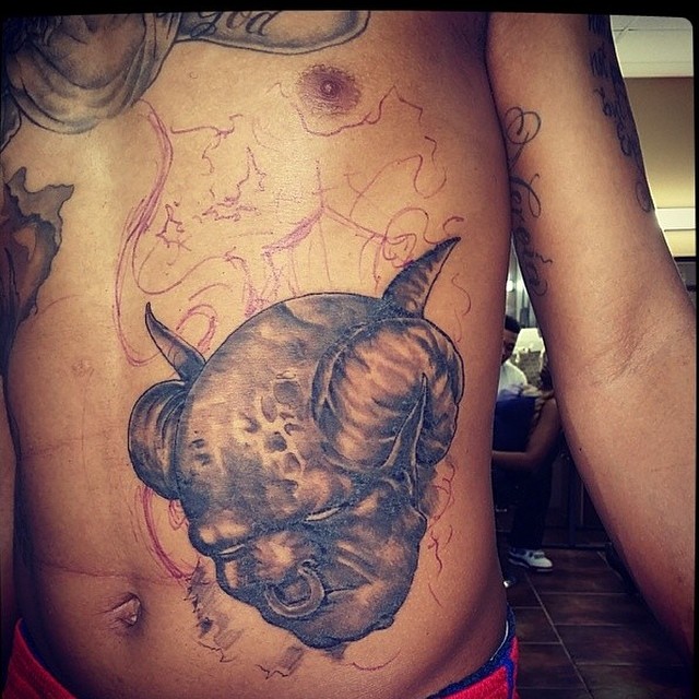 Rhino head black and grey tattoo on the chest by Sly Davis
