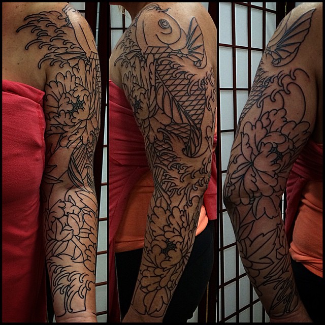 Koi fish and chrysanthemums japanese irezumi tattoo on the upper arm by Quality Tattoos done by Kurt